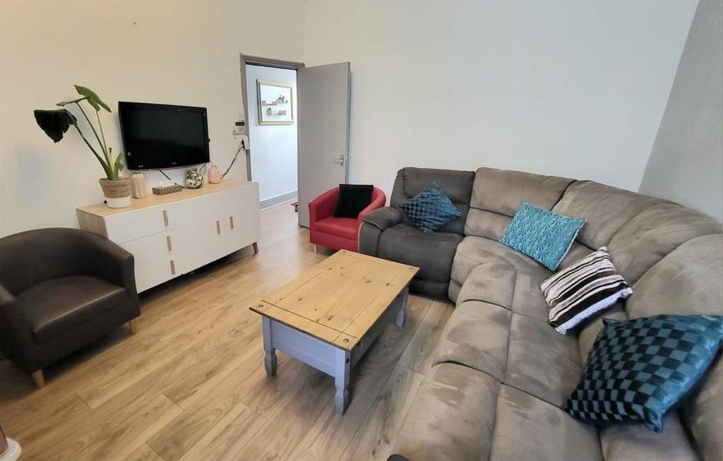 A spacious, modern living room featuring a larg...