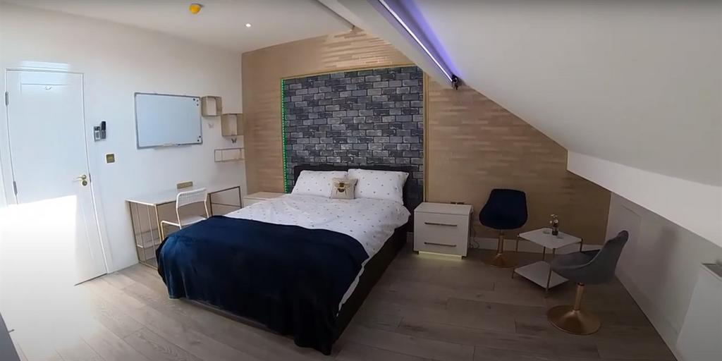 A modern, well-lit bedroom featuring a large do...