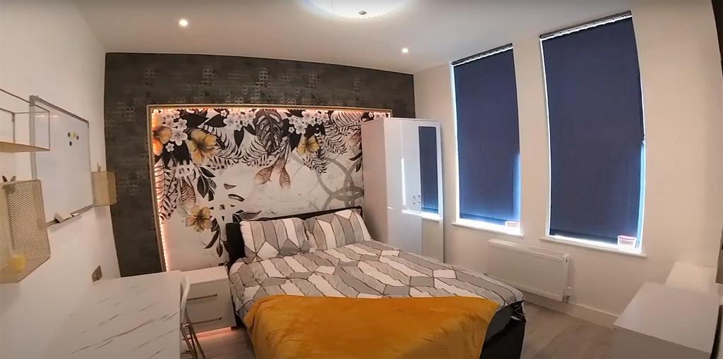 A spacious and modern bedroom featuring a large...