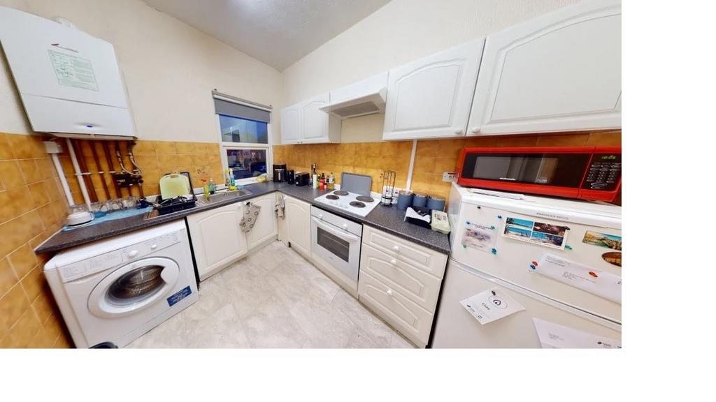 Modern kitchen with white cabinets and applianc...