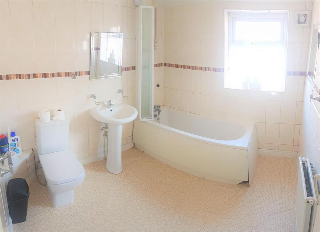 Bright, well-maintained bathroom with a curved ...