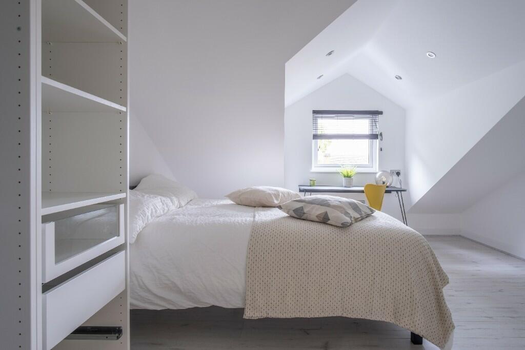 A bright and inviting double bedroom with a com...