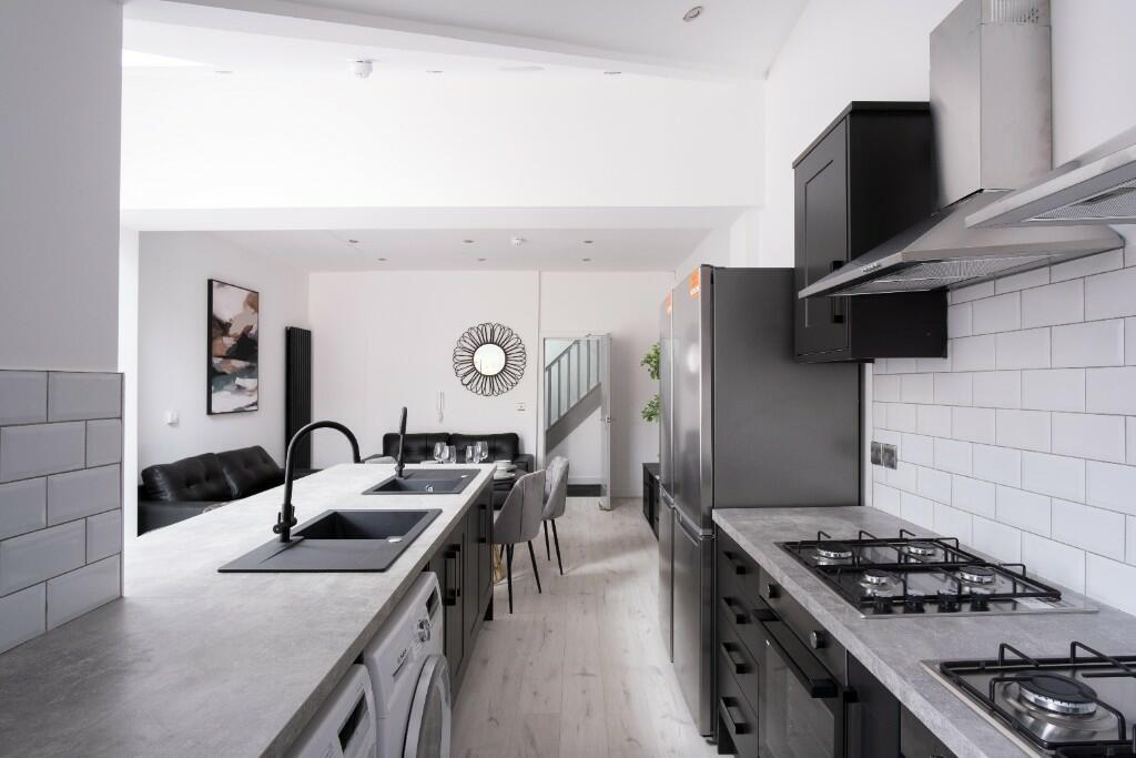 Modern kitchen with stylish grey cabinetry, whi...