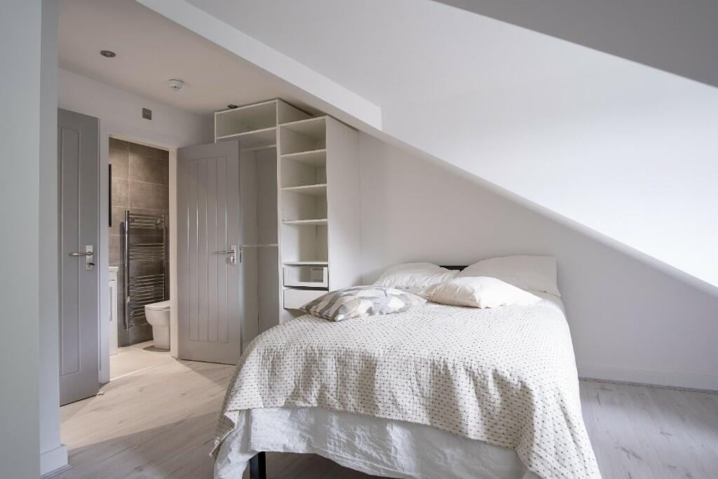 Bright and spacious master bedroom with a comfo...