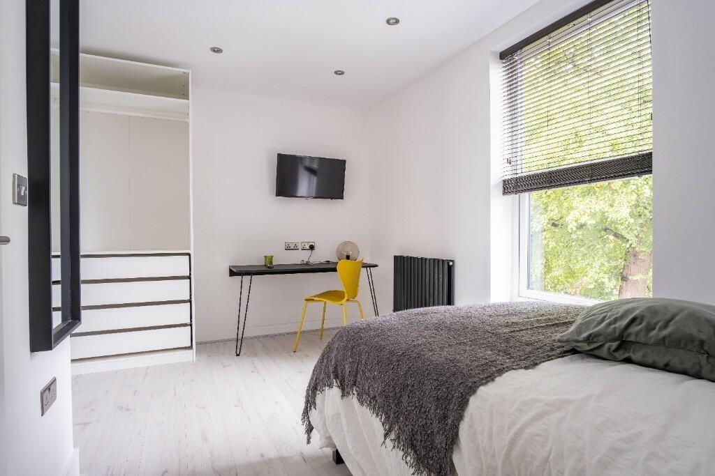A bright and inviting bedroom featuring a doubl...