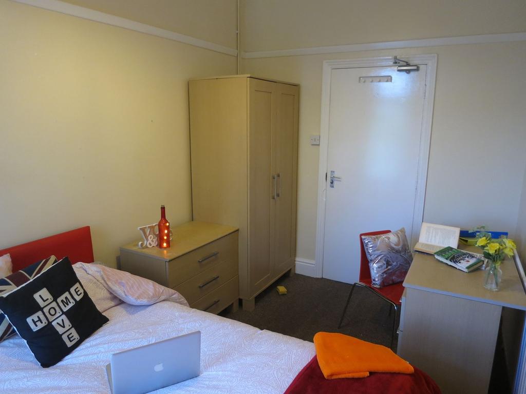 A cozy bedroom with a comfortable bed, a bedsid...