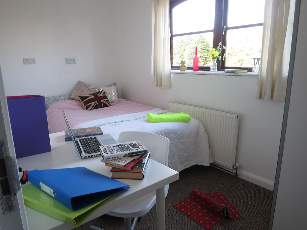 A cozy, well-lit bedroom with a comfortable dou...