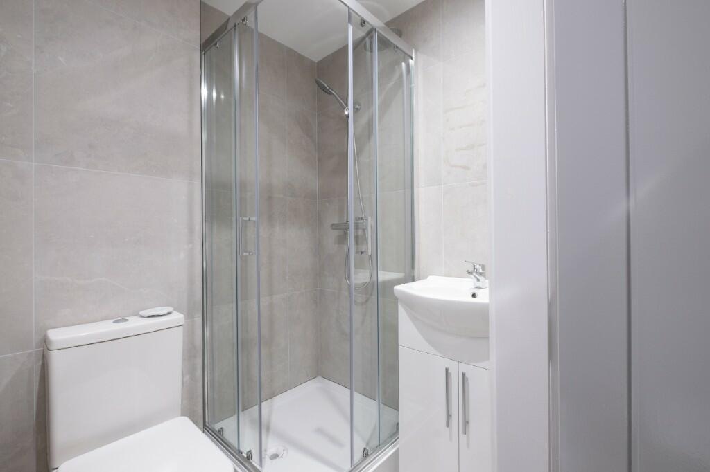 Bright, modern bathroom with a glass-enclosed s...