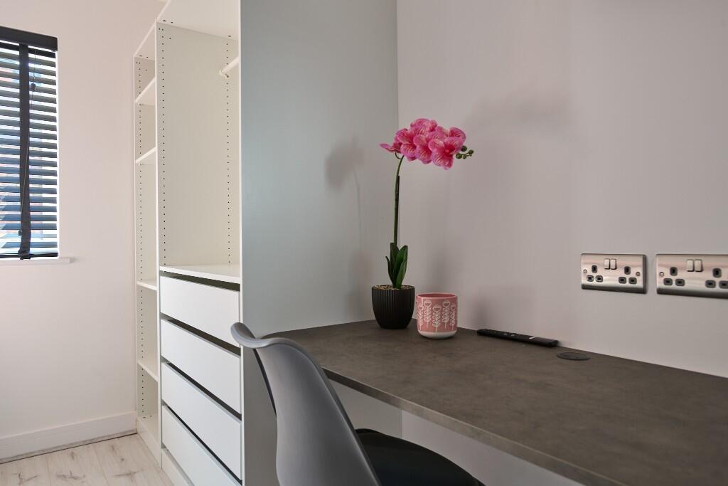 Bright, tidy study nook with a built-in desk, s...