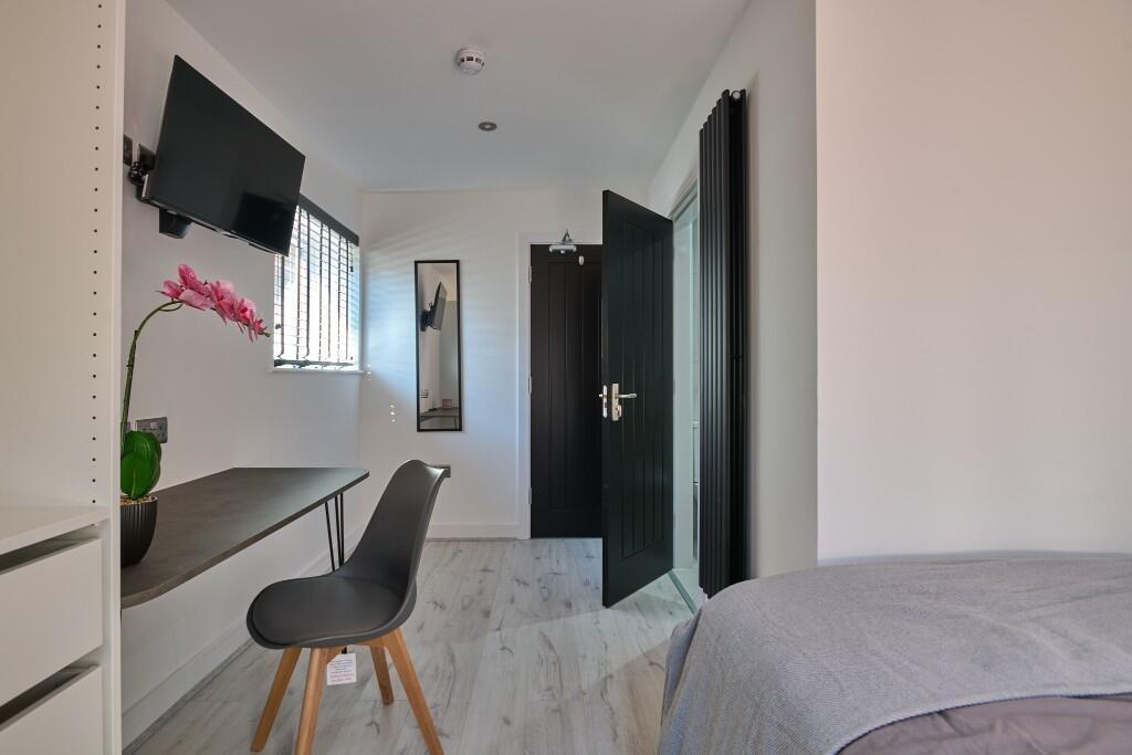 Bright, neatly presented bedroom with a wall-mo...