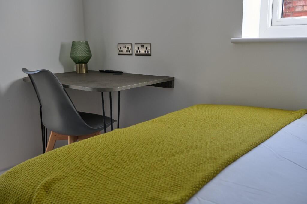 Bright, simply furnished bedroom with a comfy b...