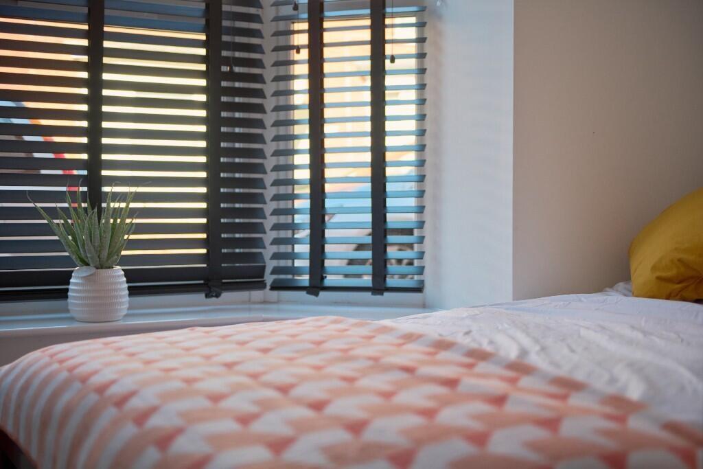Bright, neatly presented bedroom with patterned...
