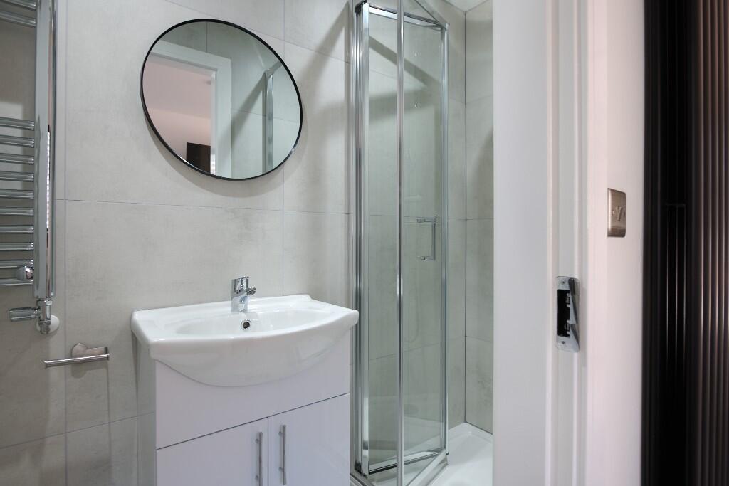 Modern bathroom with a corner glass shower encl...