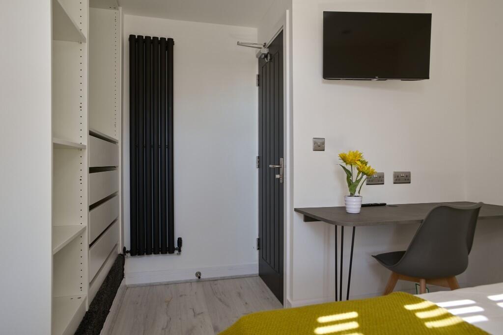 Bright, modern bedroom with built-in open wardr...
