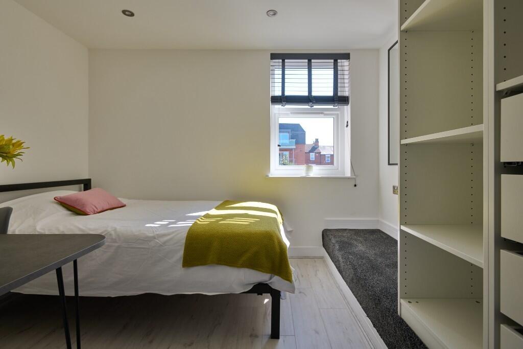 Bright, simply furnished bedroom with a double ...