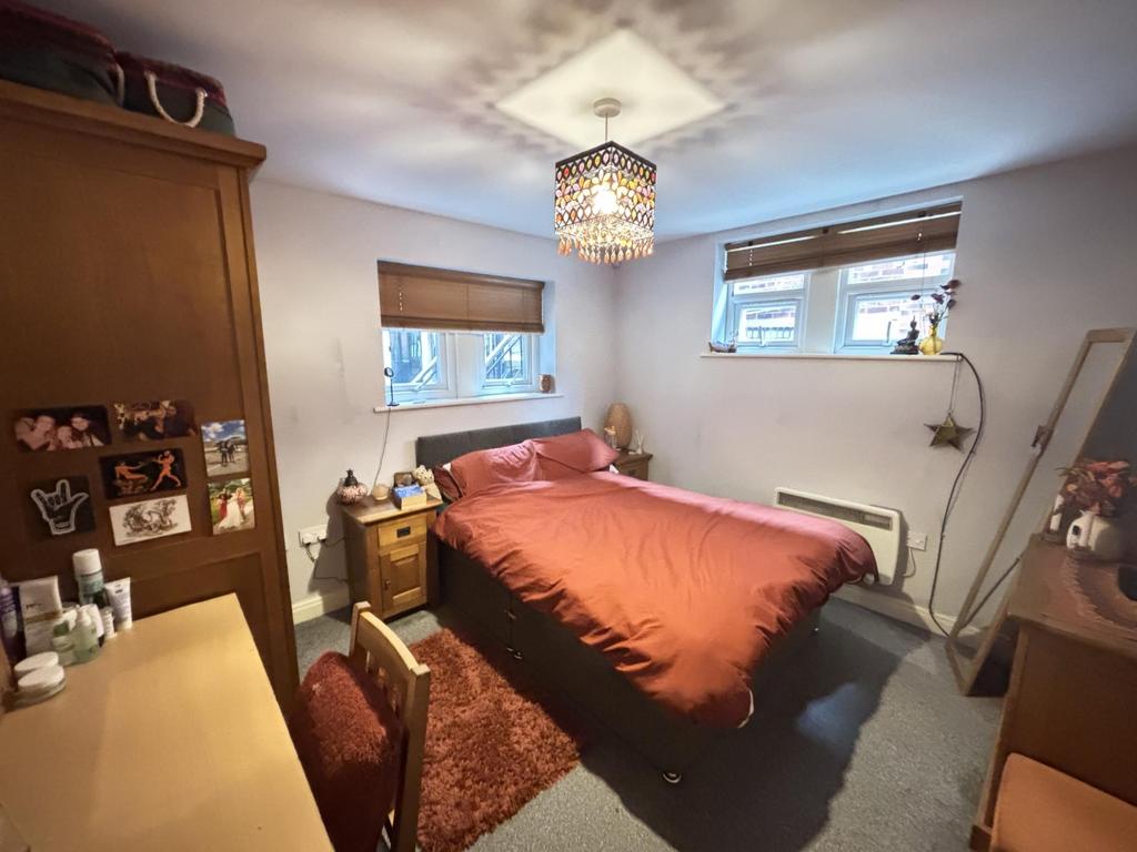 A cozy single bedroom featuring a double bed, w...