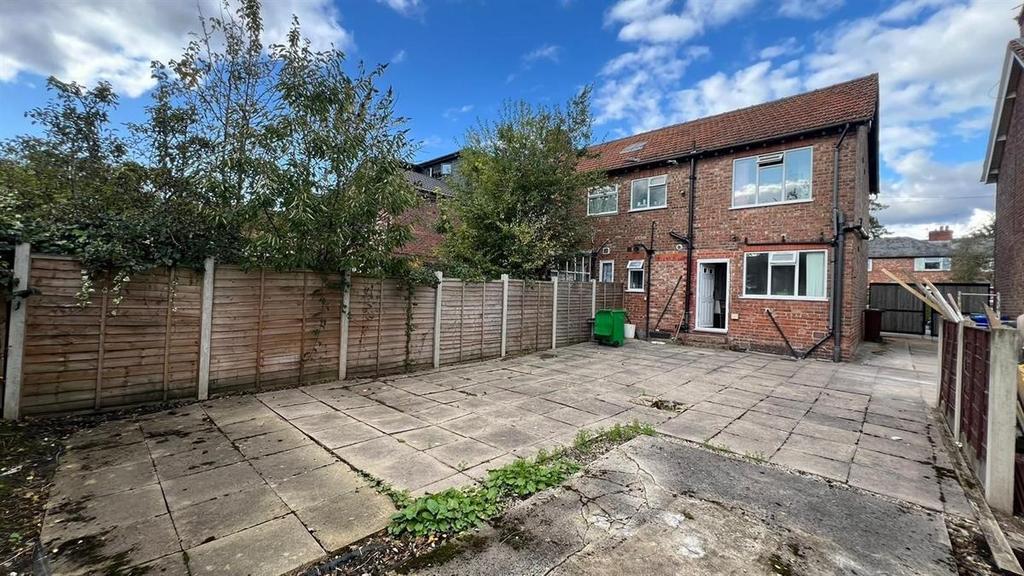 Private paved rear garden with mature trees, se...