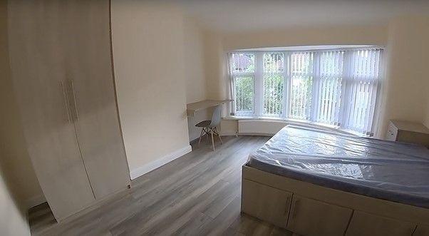 A bright, clean bedroom with a large window all...