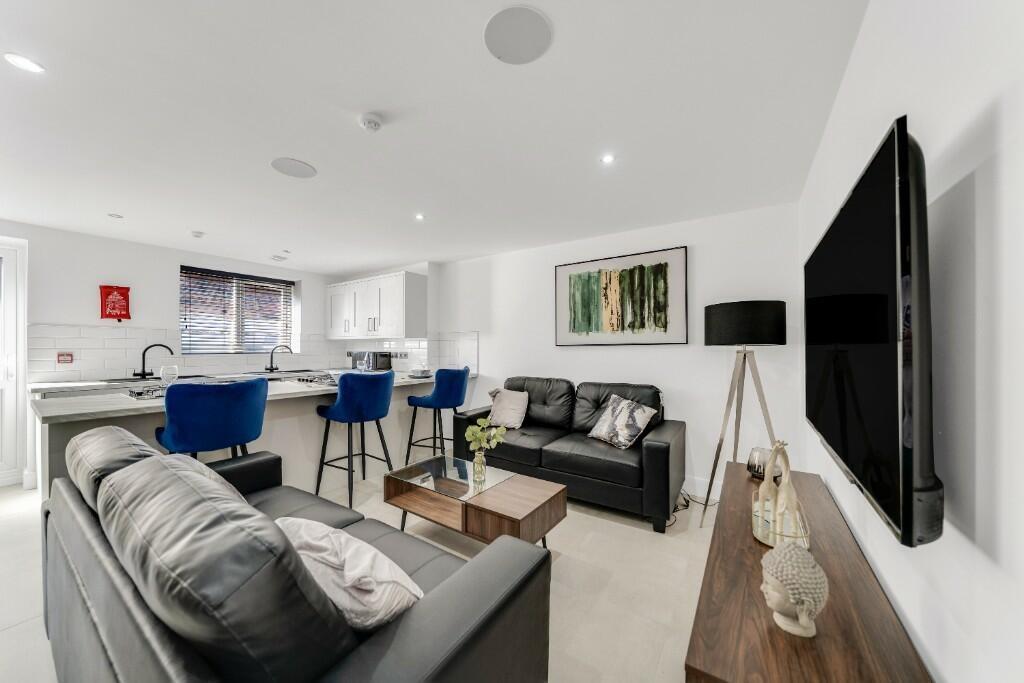 A spacious and contemporary living room featuri...