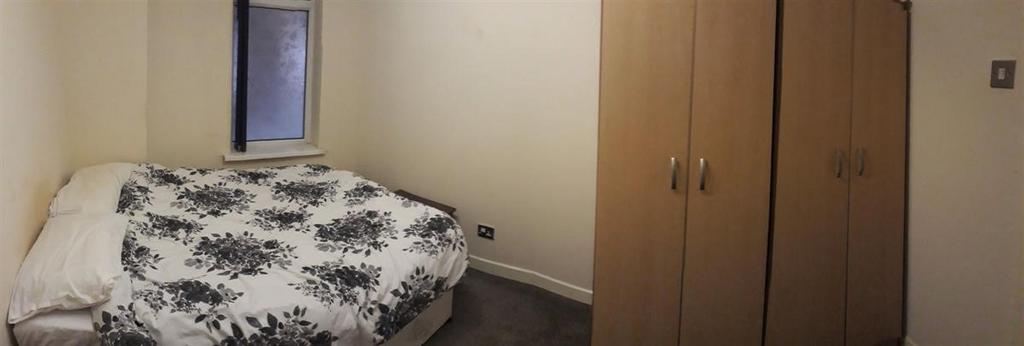 Cozy double bedroom with a patterned duvet, bui...