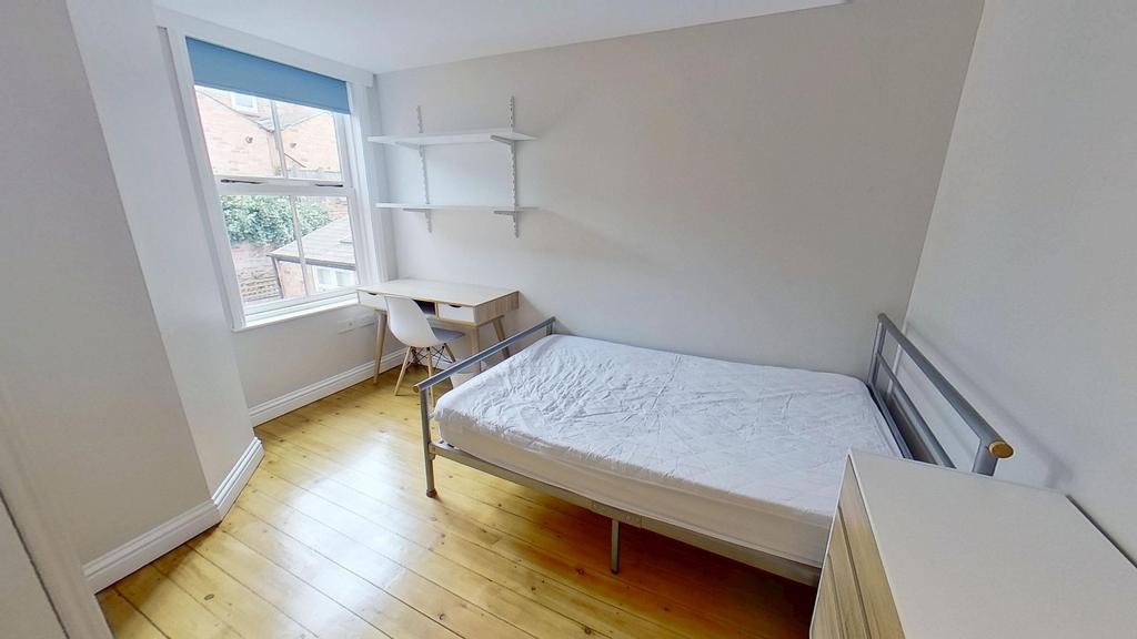Bright and clean student bedroom featuring a si...