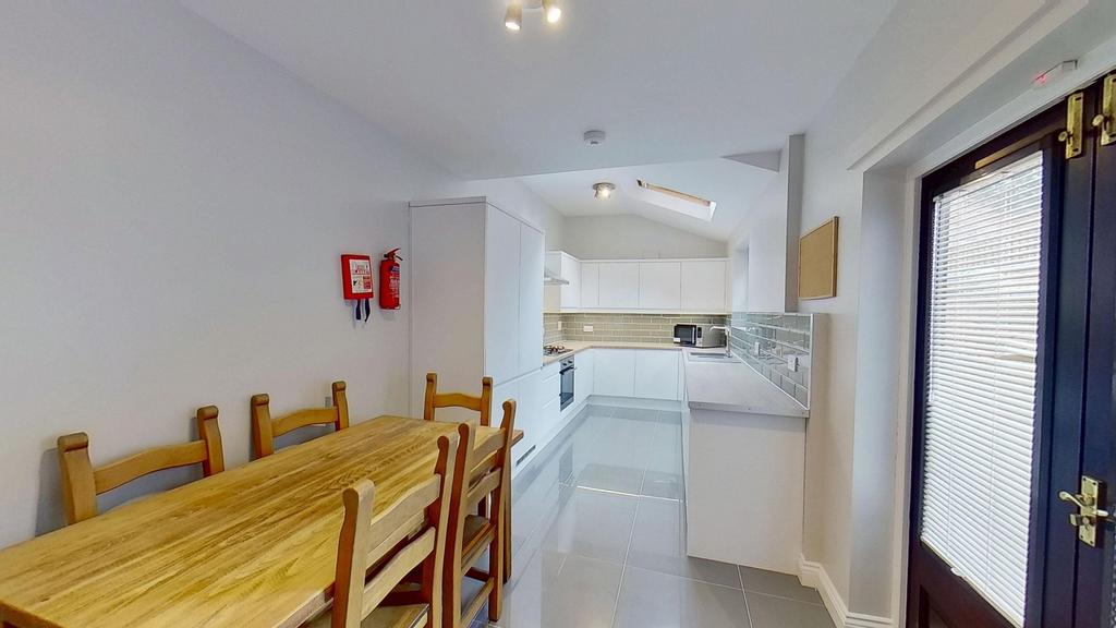 Bright and modern kitchen featuring white cabin...