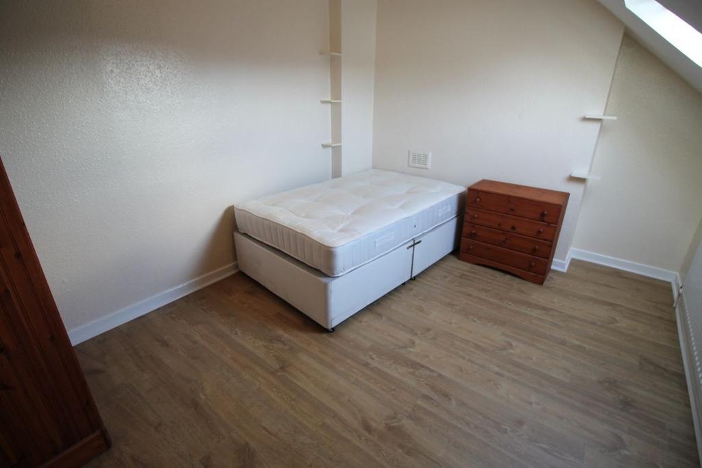 A simple single bedroom featuring a bed and a s...