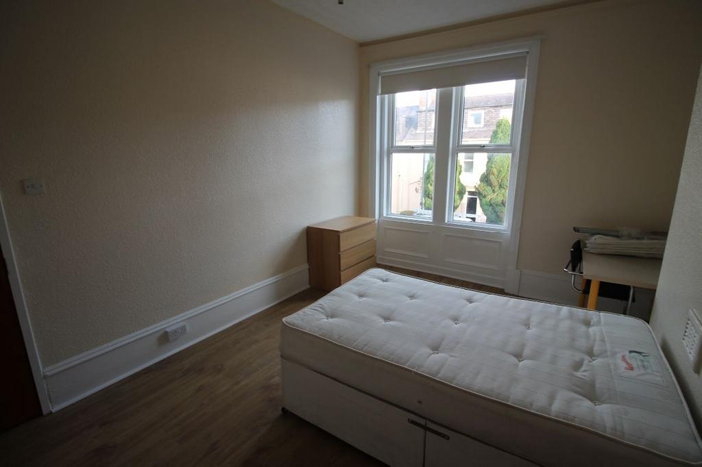 A bright and welcoming bedroom with a comfortab...
