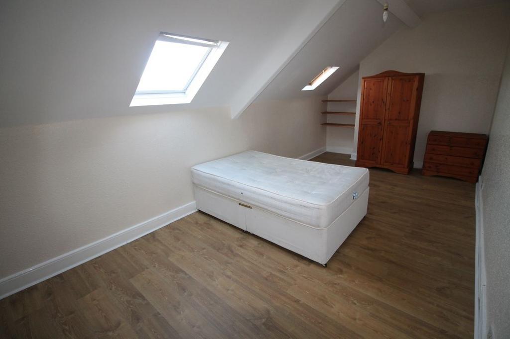 A spacious and bright bedroom with a large wind...