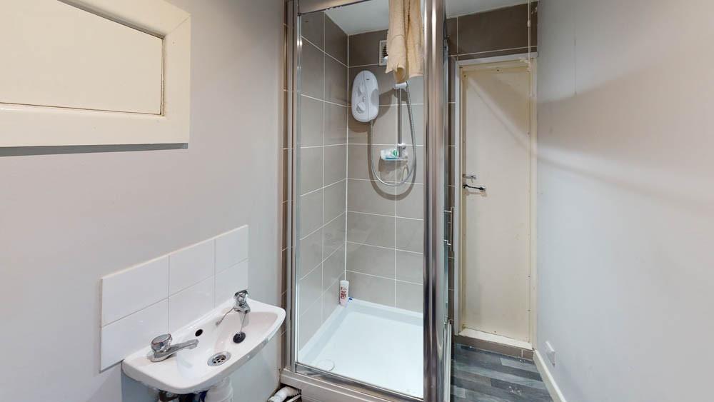 A modern, clean bathroom with a shower unit and...