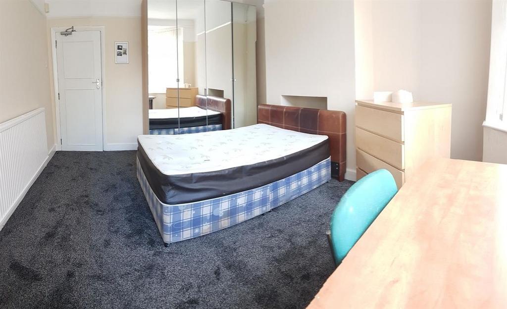 A bright and well-maintained bedroom featuring ...