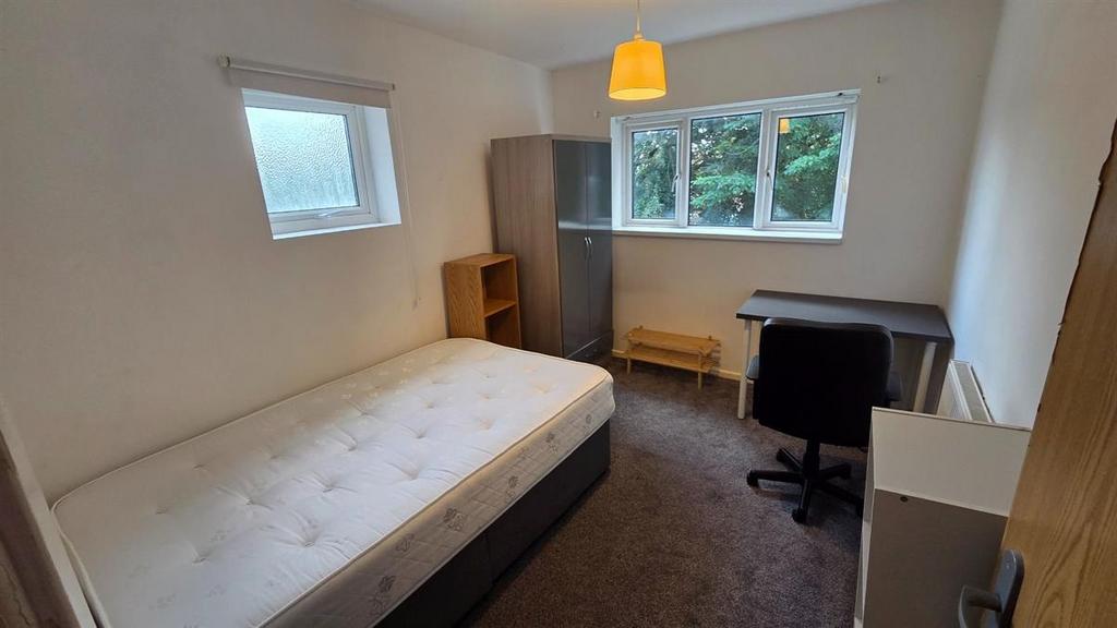 Bright, simply furnished bedroom with a mattres...
