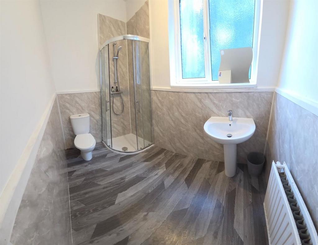 Bright, modern bathroom with a corner glass sho...