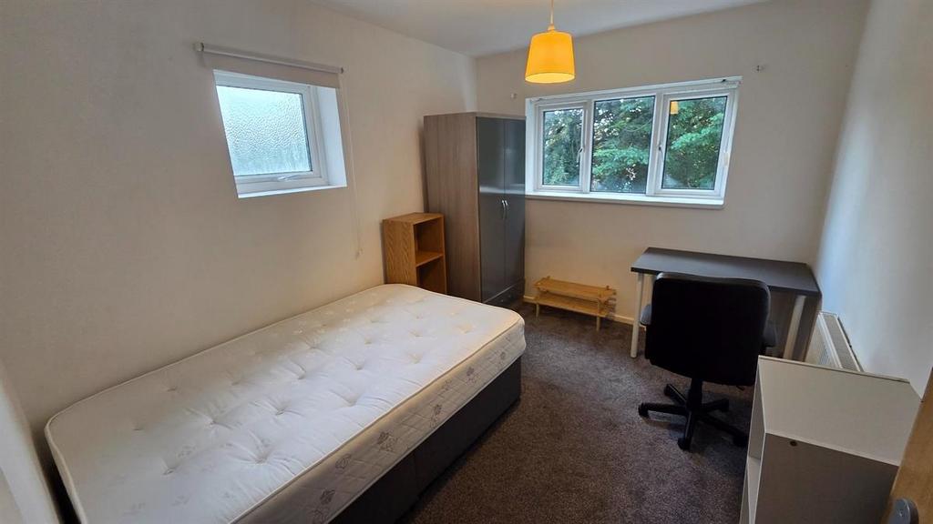 Bright, simply furnished bedroom with a comfort...