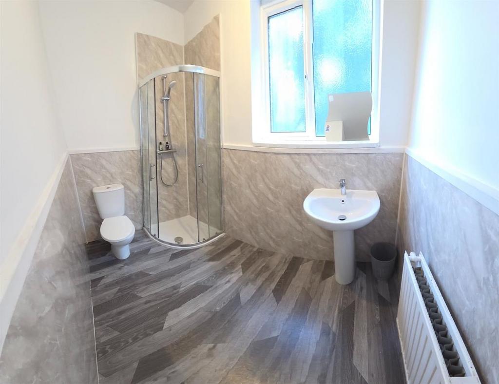 Bright, modern bathroom with corner glass showe...