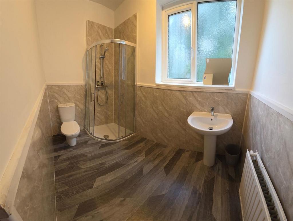 Bright, modern bathroom with a corner shower en...