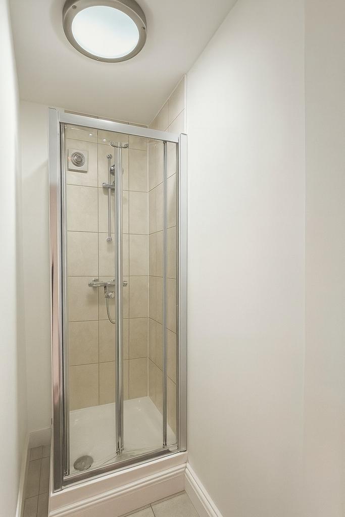Bright, modern shower cubicle with tiled walls,...