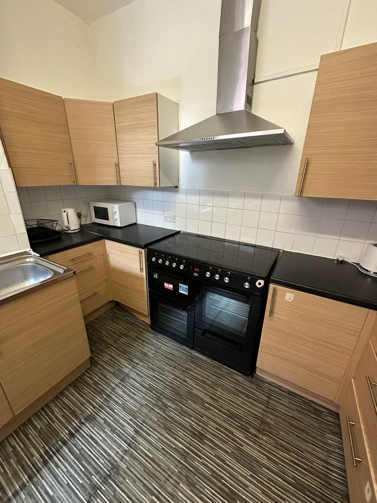 Modern kitchen featuring wooden cabinets, a bla...