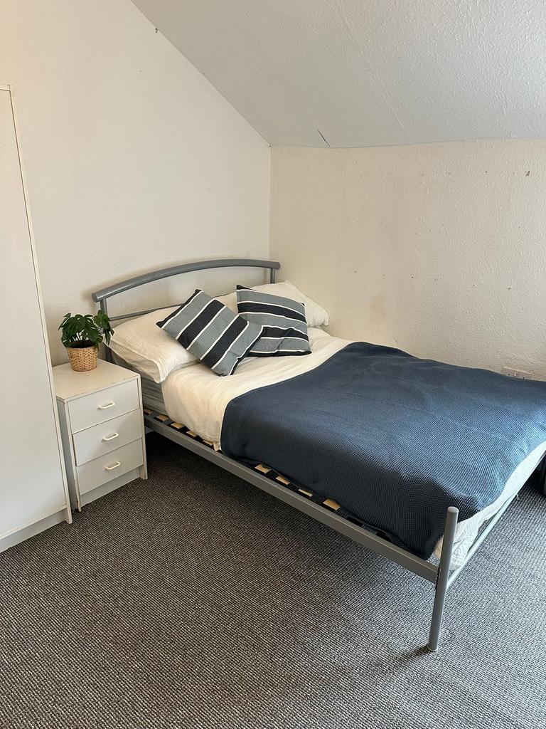 A cozy single bedroom featuring a comfortable b...