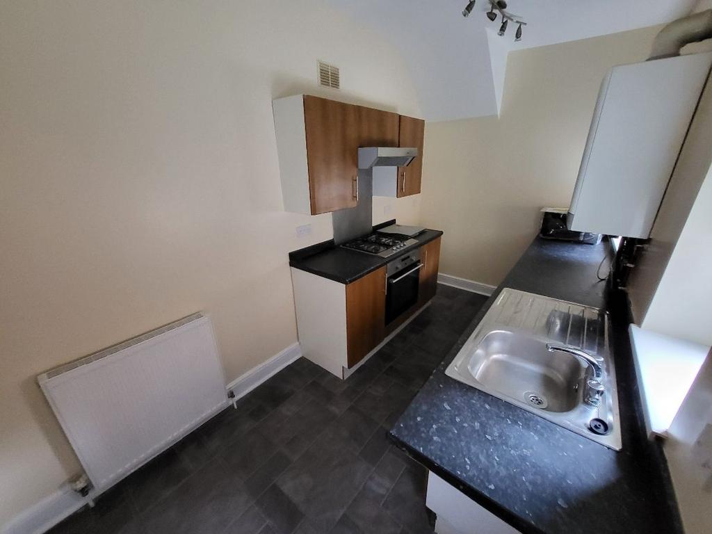 A modern kitchen area with a sleek black counte...