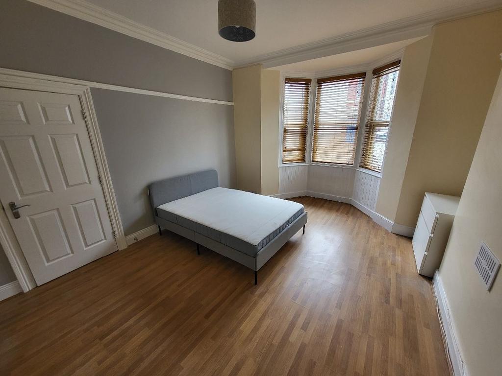 A bright, tidy single bedroom featuring a comfo...