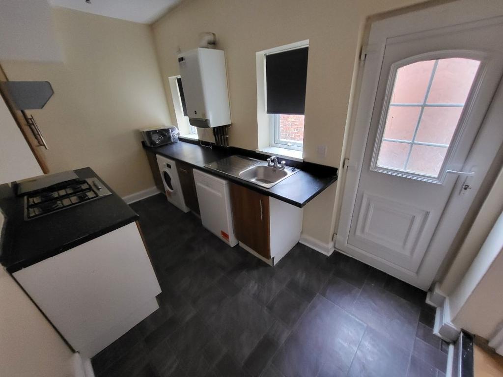 A modern kitchen area featuring a sink, counter...