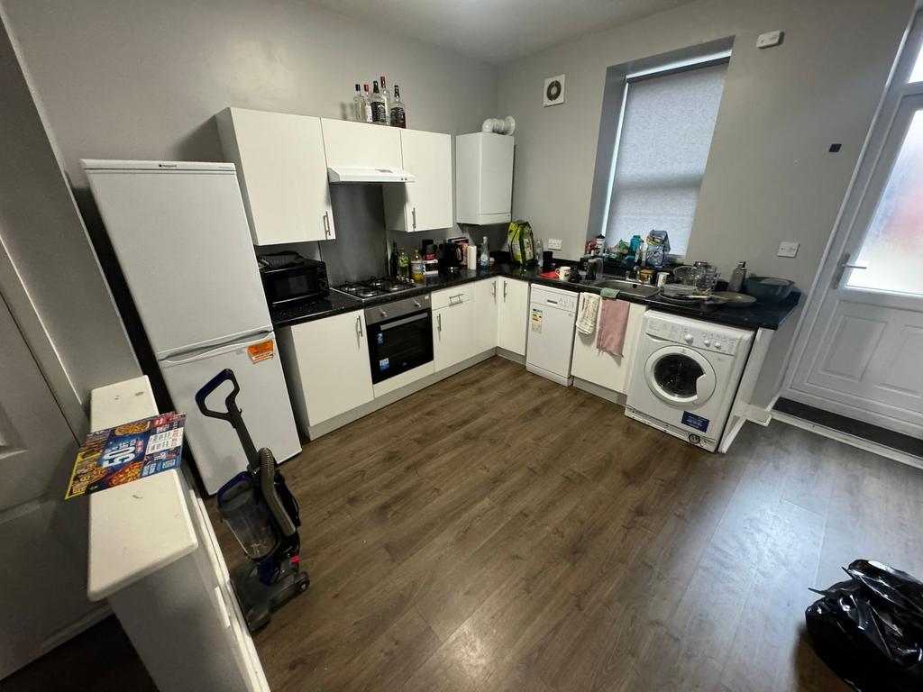 Modern fitted kitchen with white cabinets, inte...