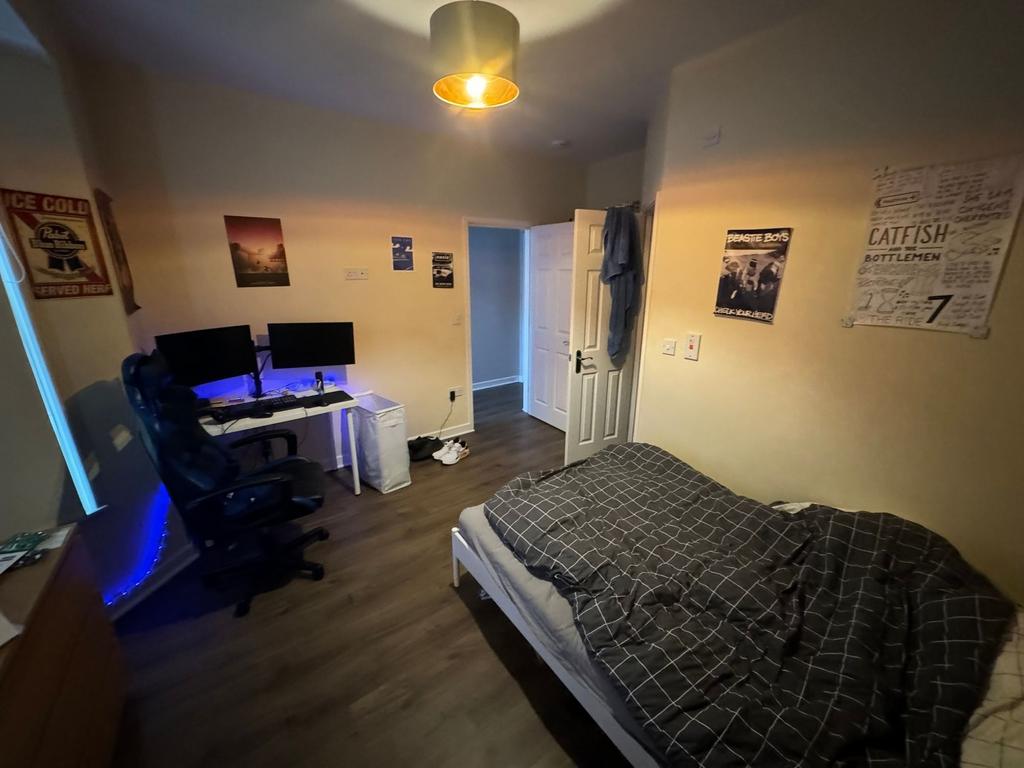 Well-presented bedroom with a cozy bed, gaming/...