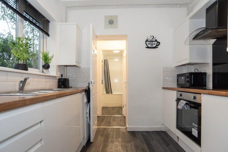 Bright modern galley kitchen with wood-effect w...