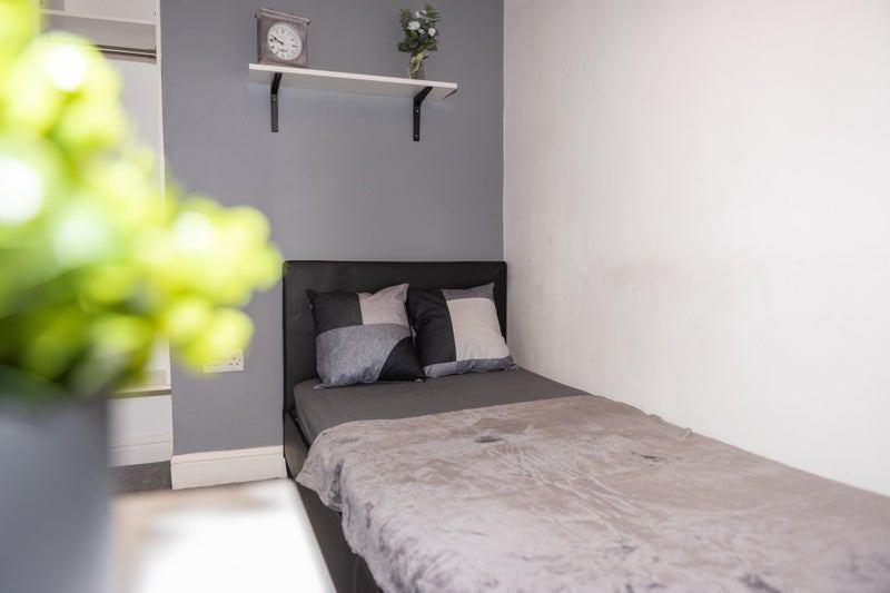 Neat single bedroom with a comfortable bed dres...