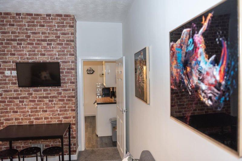 Contemporary living area with exposed brick fea...