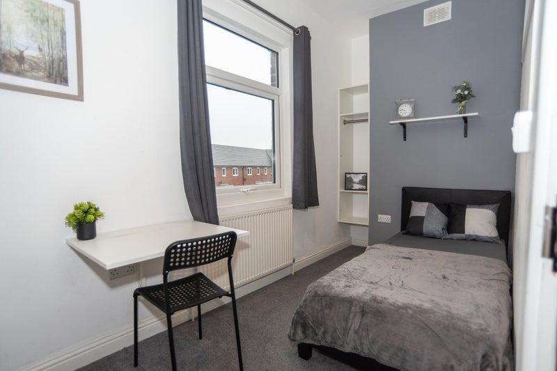 Neat single bedroom with a fitted study shelf b...