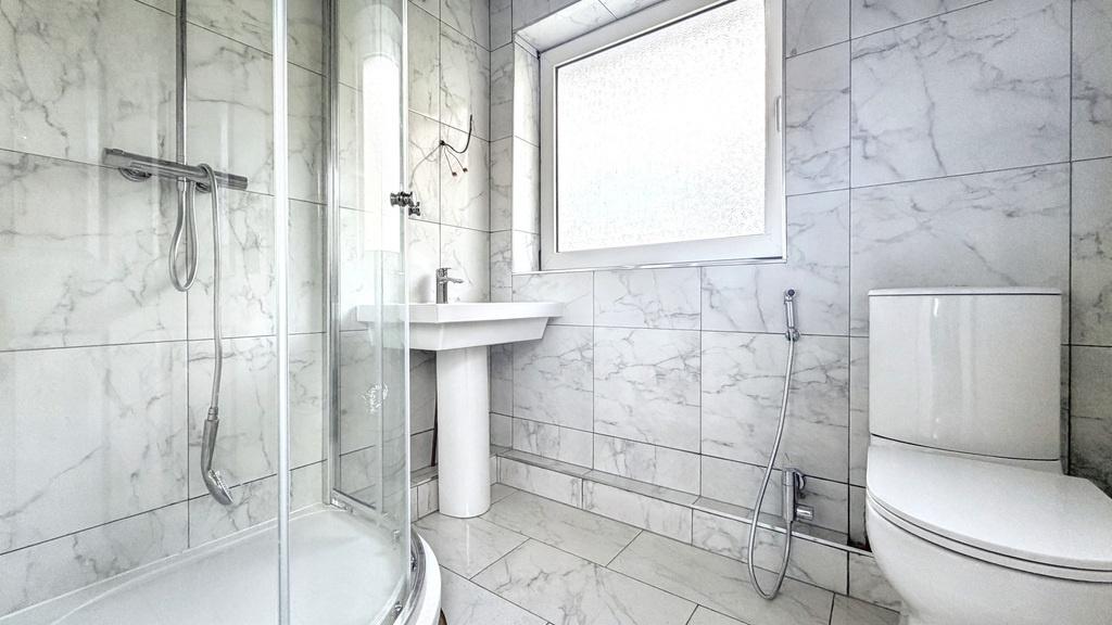 Bright, modern bathroom with marble-effect tili...