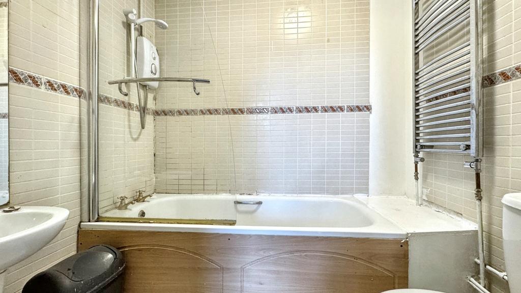 Bright, modern bathroom with a combined bath an...